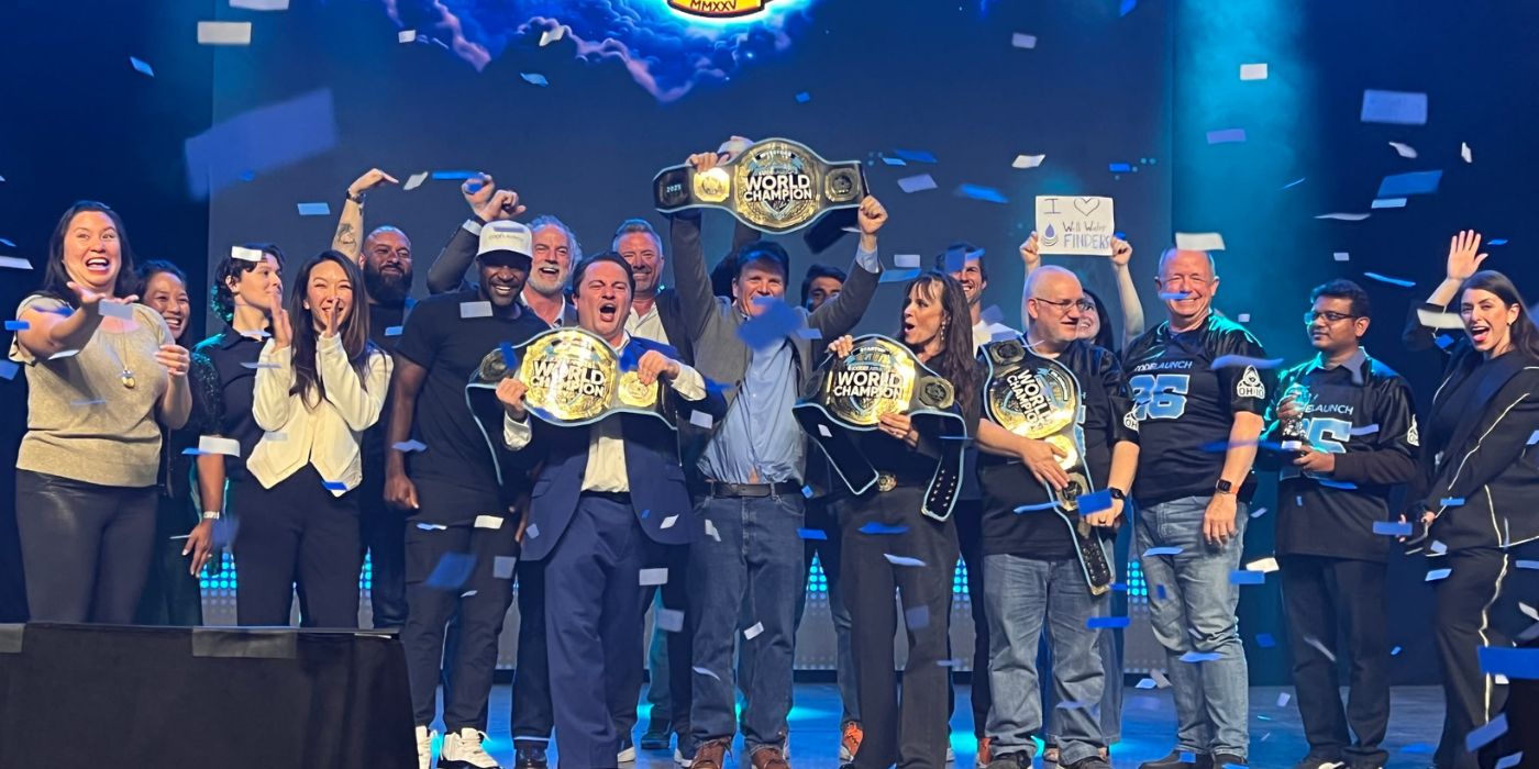 Well Water Finders team celebrates on stage with championship belts after sweeping CodeLaunch 2025 World Championship
